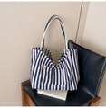 Detailed view of striped canvas tote bag with front pocket and thick cream shoulder straps - Fine Blue Stripe