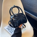 Minimalist black glossy leather shoulder bag with round handles and adjustable strap - Black