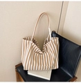 Detailed close-up of a striped canvas tote bag with front pocket on a leather chair - Narrow Stripe Khaki
