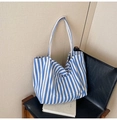 Detail of blue and white striped canvas tote bag with front pocket on a black chair - Narrow Stripe Sky Blue