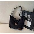 Detalle de bandolera de nailon negro con correa ajustable y parche de logo en cuero - Negro