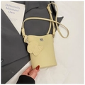 Close-up of yellow lychee grain leather crossbody bag with a cute puppy charm and knot strap - Yellow
