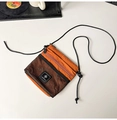 Detail of burnt orange nylon crossbody bag featuring black mesh pocket and rope strap - Orange