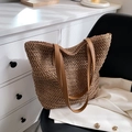 Gros plan d'un sac seau tissé marron avec des anses en cuir sur une chaise - Kaki