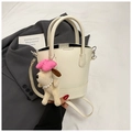 Crèmekleurige bucket bag met hondenbedeltje en zilveren hardware op grijze blazer - Beige Met Hanger