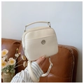 Detail of cream PU leather crossbody bag featuring dual zippers and metal logo on sofa - Off-white