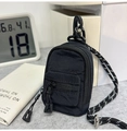 Primer plano de un mini monedero de nailon negro con cordón trenzado y gancho de plástico - Negro