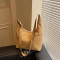 Minimalistische Nylon-Tragetasche in Erdtönen mit verstellbarem Gurt auf Ledersofa - Khaki
