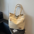 Minimalistische beige Segeltuch-Einkaufstasche mit braunem Leder-Markenetikett - Cremeweiß