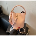 Detailed view of pink bucket bag with lychee texture and houndstooth scarf handle - Pink
