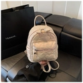 Detailed shot of beige quilted backpack with heart patterns and silver zippers - Pink