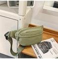 Detail van avocado groene nylon heuptas met dubbele ritsen op een houten dienblad - Legergroen