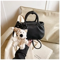 Close-up of black litchi pattern leather bucket bag with silver hardware and bear charm - With Charm / Black