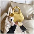 Close-up of bright yellow bucket bag with lychee texture and cute bear charm - With Charm / Yellow