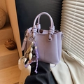 Bolso tipo cubo lavanda minimalista con asa anudada y accesorios de dijes creativos - Púrpura (Con Colgante)