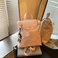 Pink minimalist faux leather backpack with a cartoon charm pendant in a lifestyle setting - Pink with Pendant
