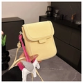 Dettaglio borsa porta cellulare gialla con trama litchi, cordino rosa e charm unicorno - Giallo con Ciondolo
