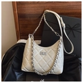 Détail d'un sac à main beige matelassé avec chaîne argentée et fermoir rotatif en métal - Abricot Lait Petit