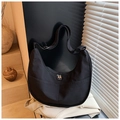 Dettaglio della borsa a mezzaluna in nylon nero con zip argentate e trama del tessuto - Nero