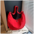 Dettaglio della borsa hobo in nylon rosso con cerniera e cuciture curve sulla tracolla - Rosso