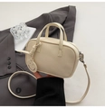 Dettaglio della mini borsa Boston in pelle martellata bianco crema con ciondolo a sorriso - Bianco Sporco