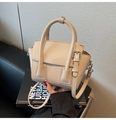 Dettaglio della borsa beige in pelle martellata con manico ad anello e fibbie in metallo - Cachi