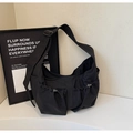 Detail view of black nylon messenger bag with drawstring pockets and wide shoulder strap - Black