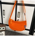 Detailansicht einer leuchtend orangen Halbmond-Umhängetasche mit blauem Etikett und Reißverschluss - Orange