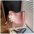 Détail du cabas en cuir rose à texture litchi avec poignée en corde et charm ours - Rose