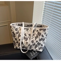 Detail van grote tote bag met koeienprint en dubbele handvatten op luxe zitting - Stijl 1 Rijstwit