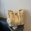 Beige canvas tote bag with side pockets and a round zipper pouch charm for daily use - Khaki