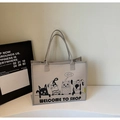 Dettaglio della borsa tote in feltro con stampa cartoon su un tavolo minimalista - Grigio