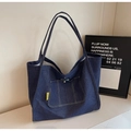 Detail der dunkelblauen Denim-Tragetasche mit gelbem Webetikett und aufgesetzter Tasche - Dunkelblau