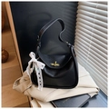 Détail du sac en cuir grainé noir avec fermoir doré et ornement de perles et dentelle - Noir avec pendentif