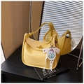 Dettaglio della borsa in pelle litchi gialla con chiusura a rotazione dorata e ciondolo - Con Ciondolo / Giallo