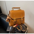 Detail der braunen Ledertasche mit Bärenmustern und weißen Nähten auf einem Luxusbuch - Braun mit Anhänger