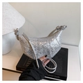 Close-up of shiny silver sequined crescent bag featuring unique knotted handle design - Silver