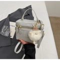 Detailed view of gray box-shaped crossbody bag with gold zippers and plush sheep charm - Grey with Charm
