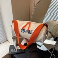 Bolso cilíndrico de lona blanco roto con bordado azul y correa naranja vibrante - Blanco Roto
