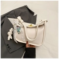 White lychee texture half-moon bag with gold lock and lace charm on grey suit - Beige With Charm