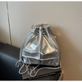 Close-up of silver drawstring bucket bag featuring metallic texture and rivet pockets - Silver