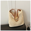 Detail of hollow-out woven tote bag featuring beige texture and brown leather straps - Beige