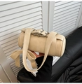Detail of a beige cylinder bag featuring a large bow and silver buckle strap detail - White