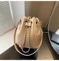 Close-up of beige pleated bucket bag featuring silver chain drawstring and leather strap - Khaki