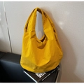Detail of a yellow nylon tote bag with washed texture and wide shoulder straps on a sofa - Yellow