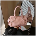 Detalle de textura de cuero rosa y herrajes metálicos en el bolso Boston - Rosa
