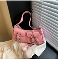 Close-up of pink fashion shoulder bag with glossy finish and metal buckle detail - Pink