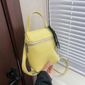 Bright yellow crossbody bag with lychee texture and heart charm in hand display - Yellow with Pendant
