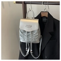Detail eines silbernen Metallic-Rucksacks mit Plissee-Struktur und Logo-Plakette - Silber