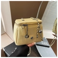 Detail of a light yellow lychee pattern square crossbody bag with floral metal charms - Large / Yellow